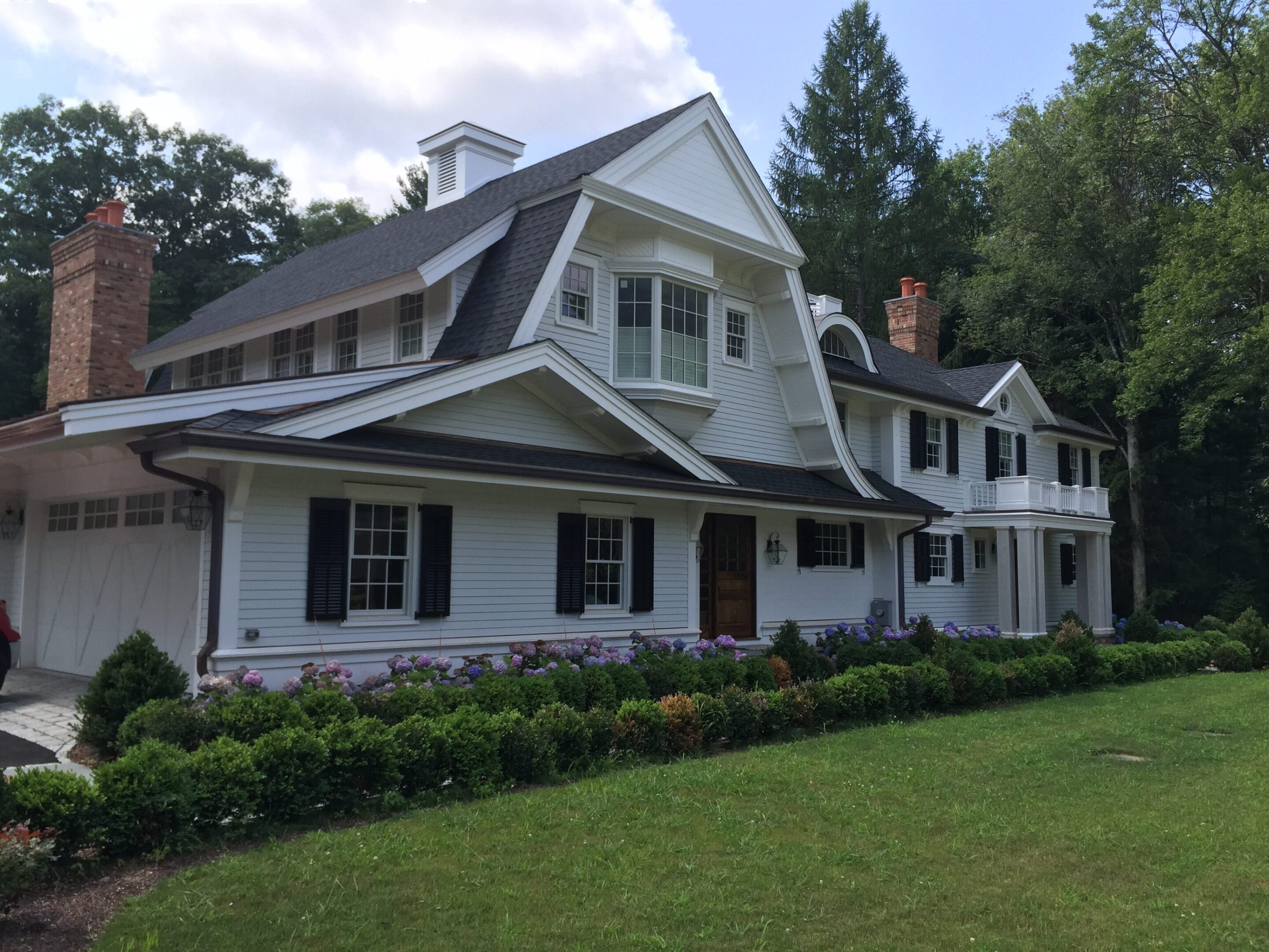 A large white house with black shutters and windows.