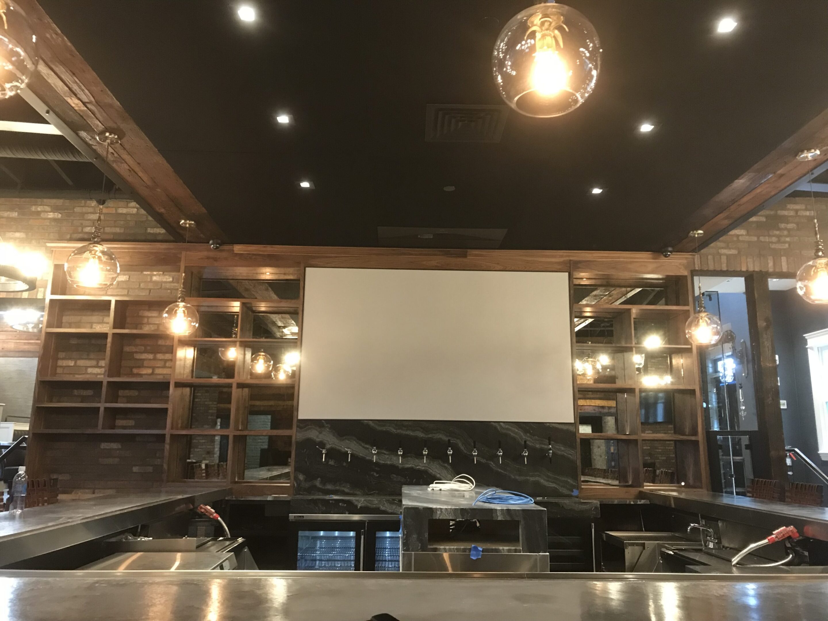 A large room with a projector screen and lights.
